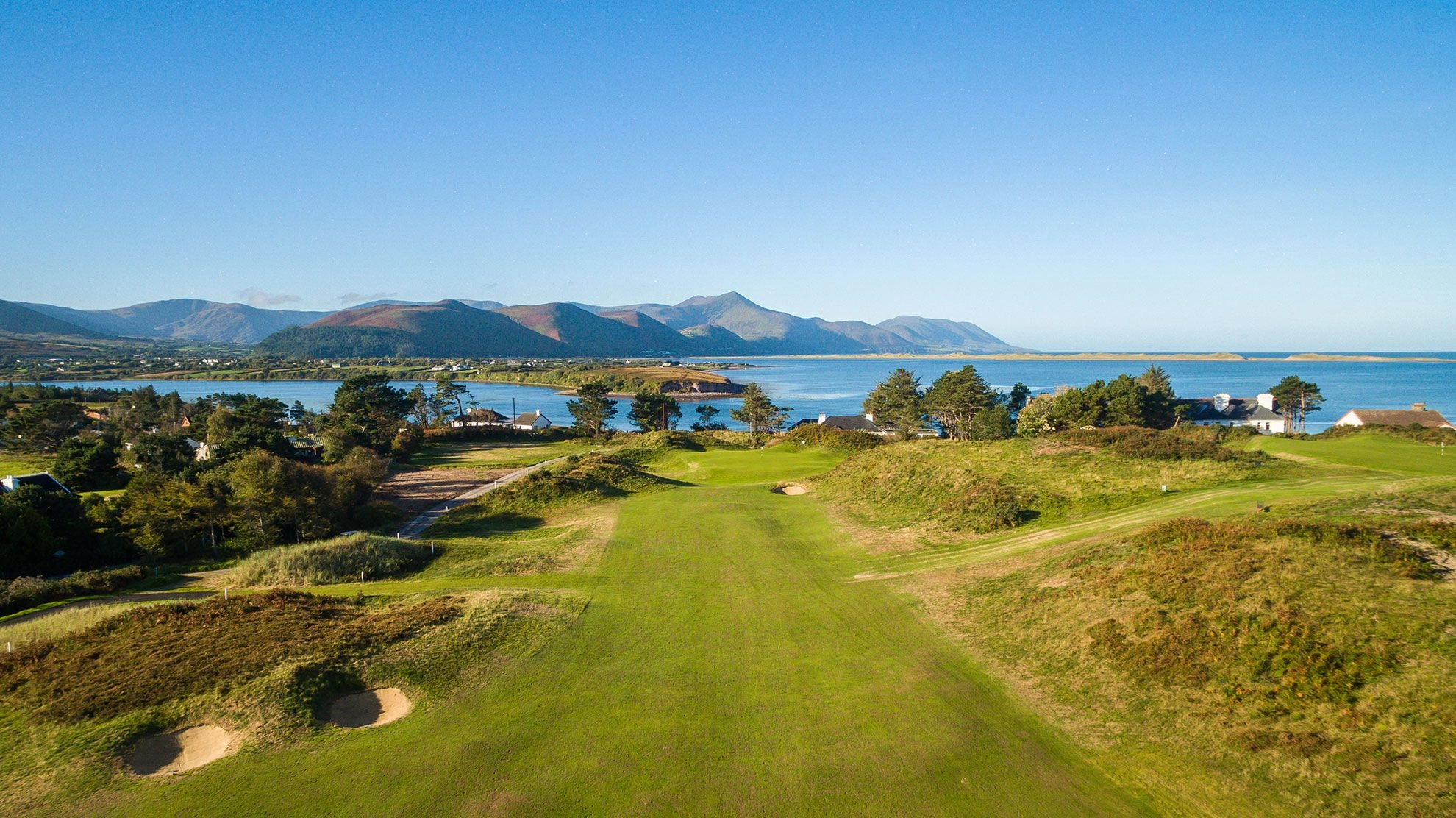 View of Dooks Golf Club with manicured fairways, greens, and surrounding natural landscape under a clear sky