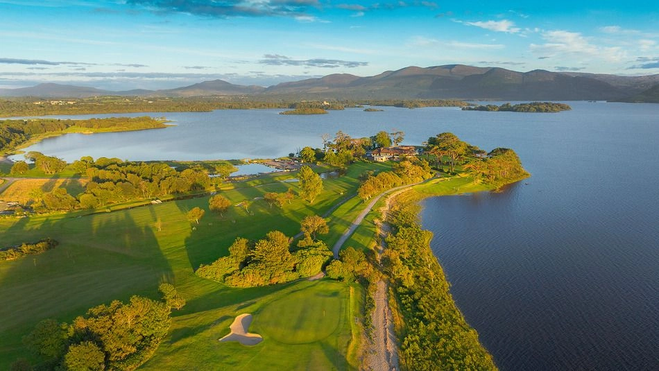 View across Killarney Golf Course with manicured fairways, greens, and surrounding trees under a bright sky